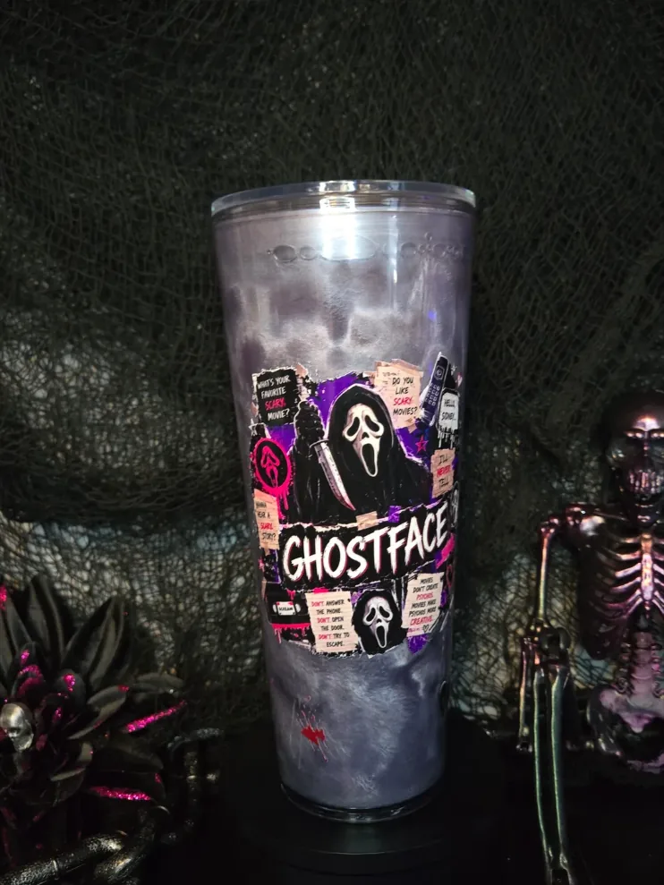 Tall 24 oz smoky grey tumbler with a collage of horror-movie quotes around a masked figure.